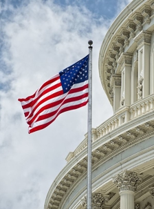 Image of the American flag waving in front of a court house building